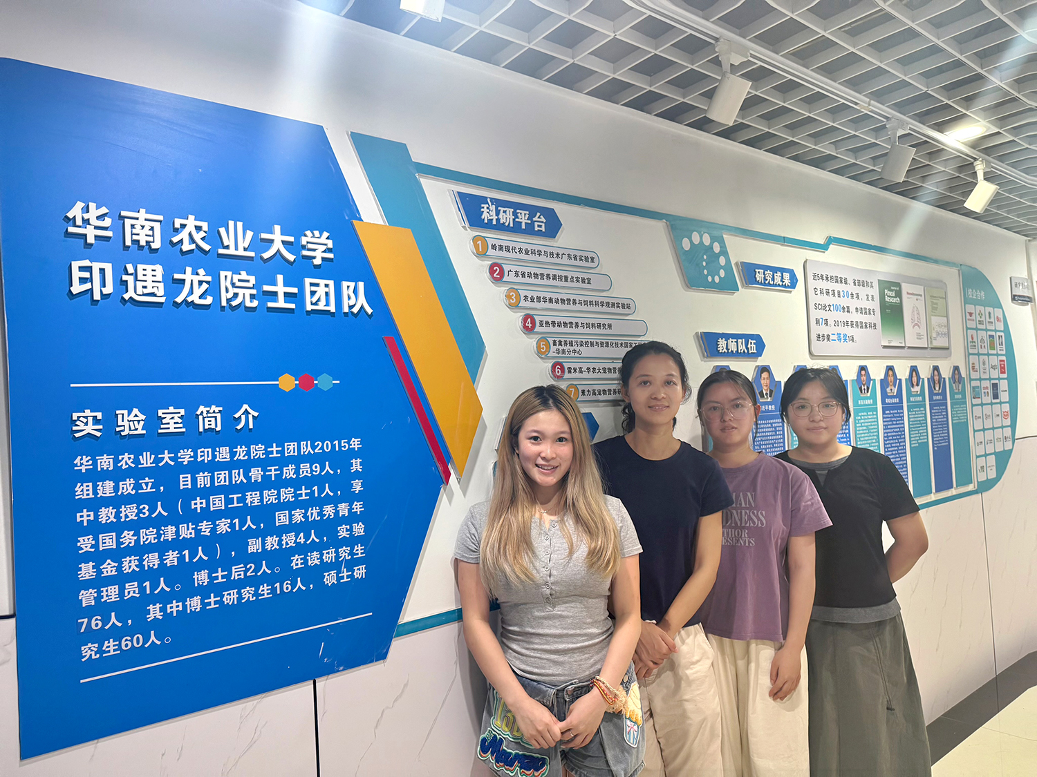 A group of people posing in front of a sign.