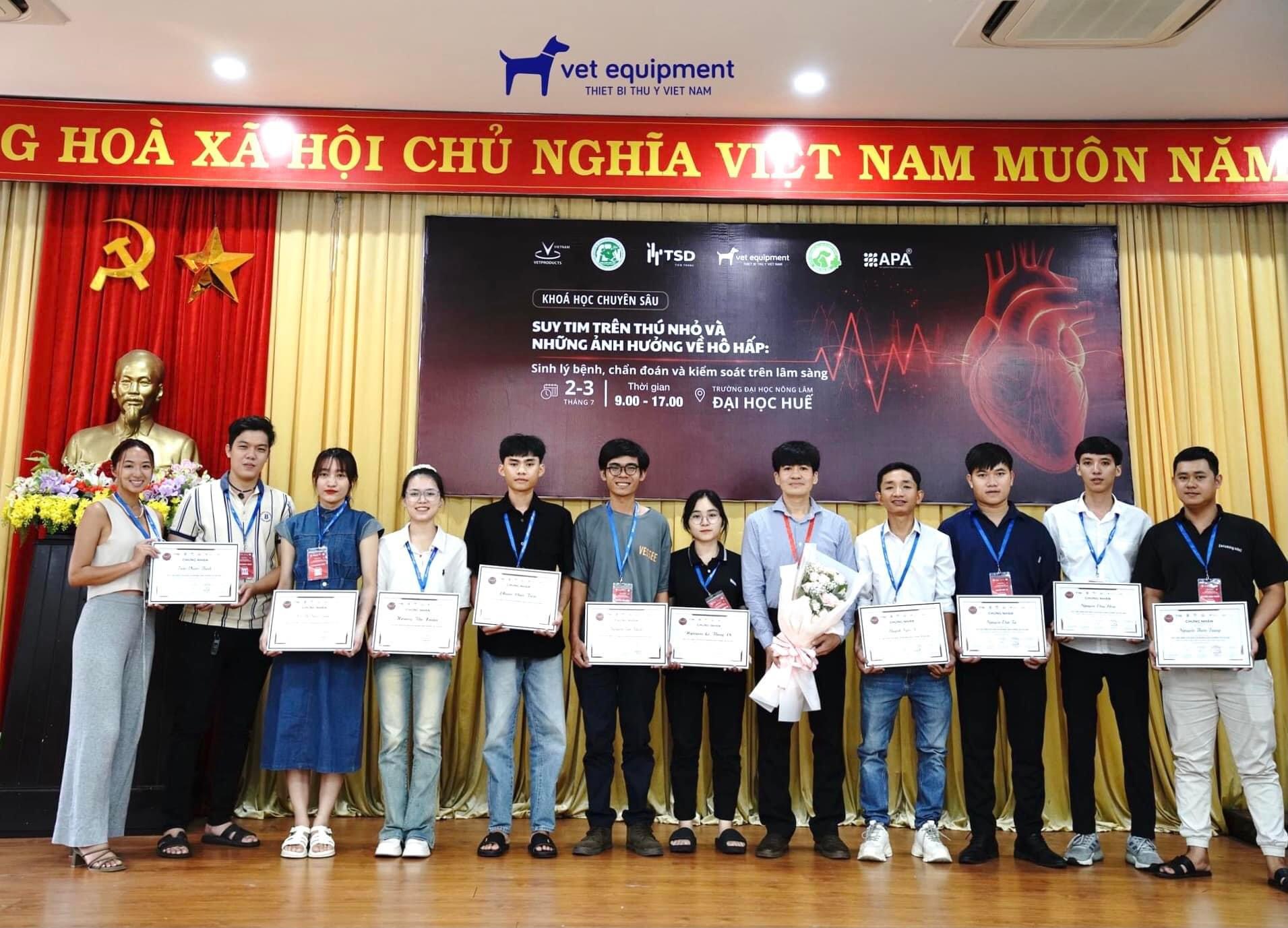 A group of people standing on a stage holding certificates.