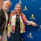 Two people standing next to a UC Davis sign.