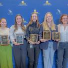group of veterinarians holding award plaques